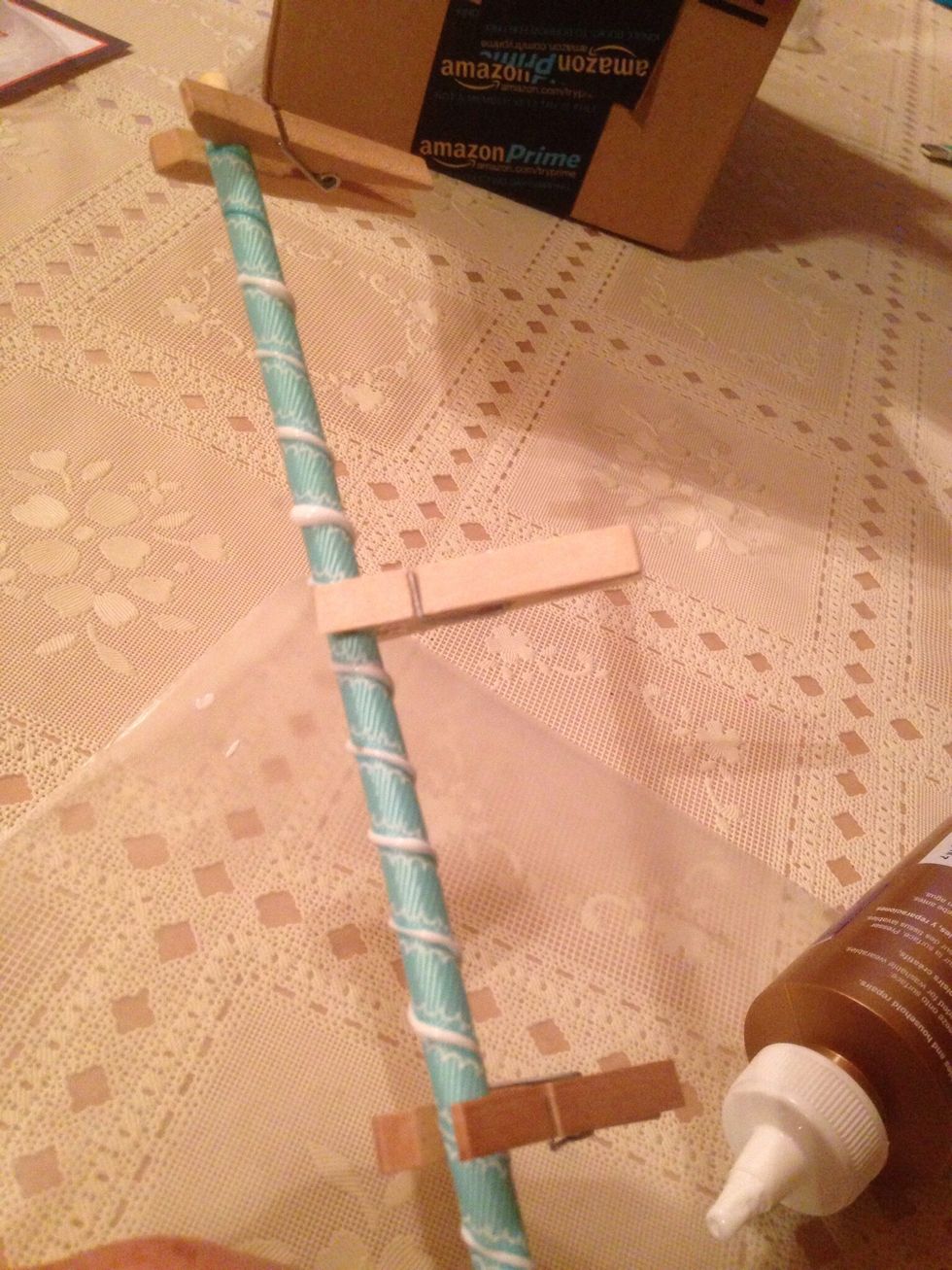 Use the clothes pins to clip about every three inches or so on the dowel. This will keep the ribbon in place as you wait for the glue to dry.