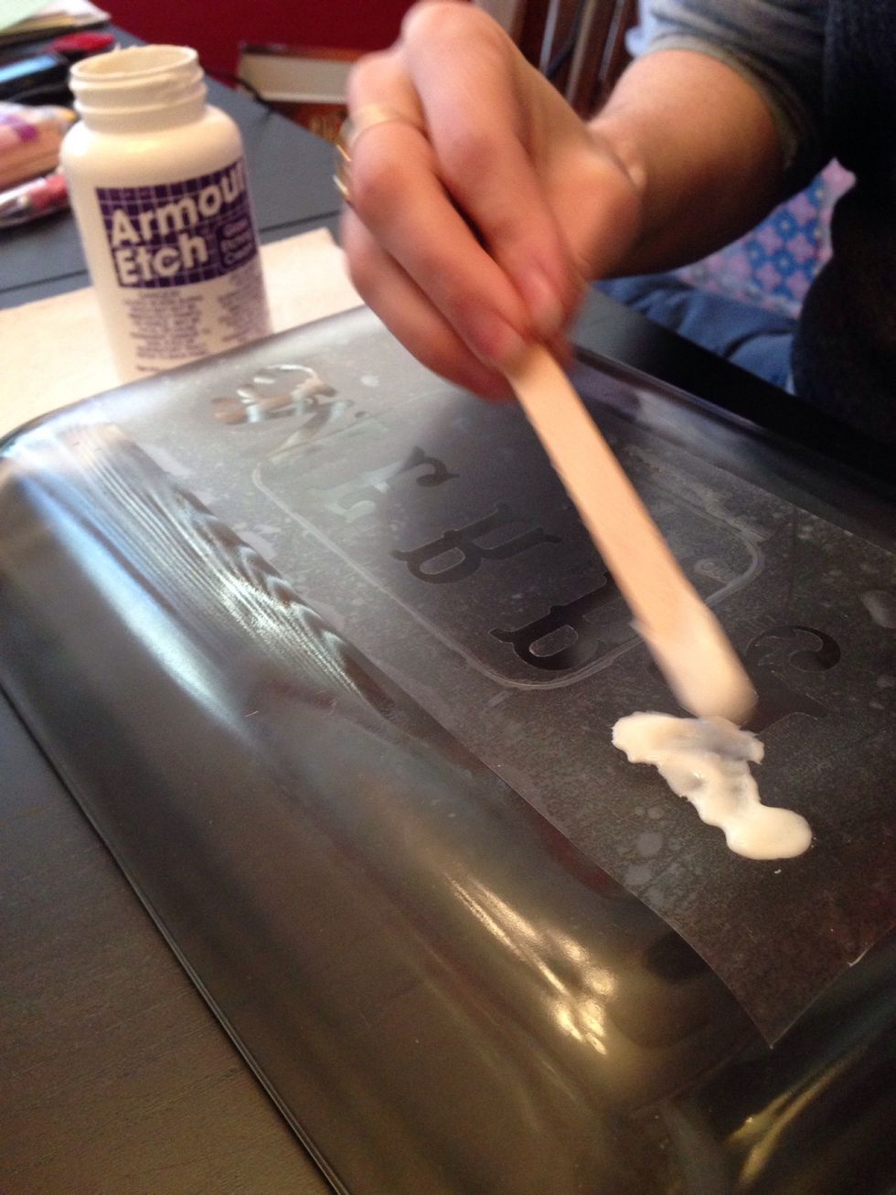 Use the craft stick to spread the etching cream over the desired area.