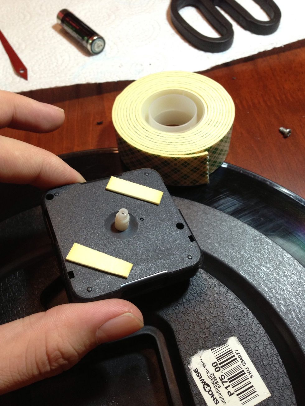 Use the double sided tape to attach the mechanism to the LP record. Make sure you properly align the mechanism with the label in front.