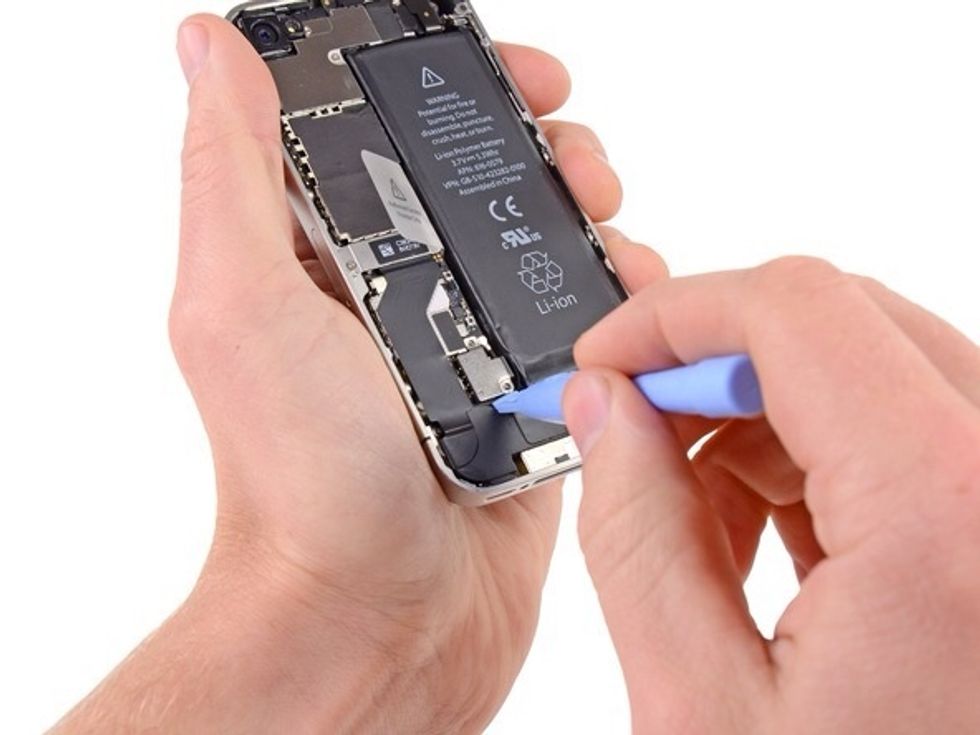 Use the edge of a plastic opening tool to gently pry the battery connector up from its socket on the logic board.