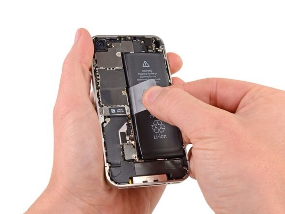 Use the exposed clear plastic pull tab to peel the battery off the adhesive securing it to the iPhone. Remove the battery.