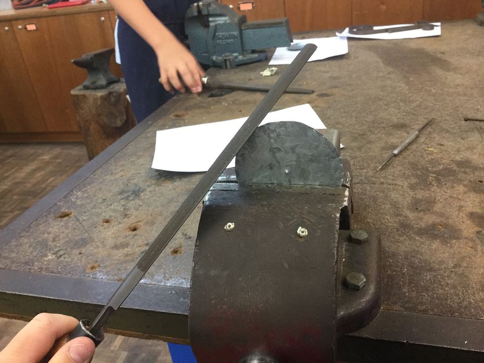 Use the file to file down the edges of the sheet metal and make it smooth.