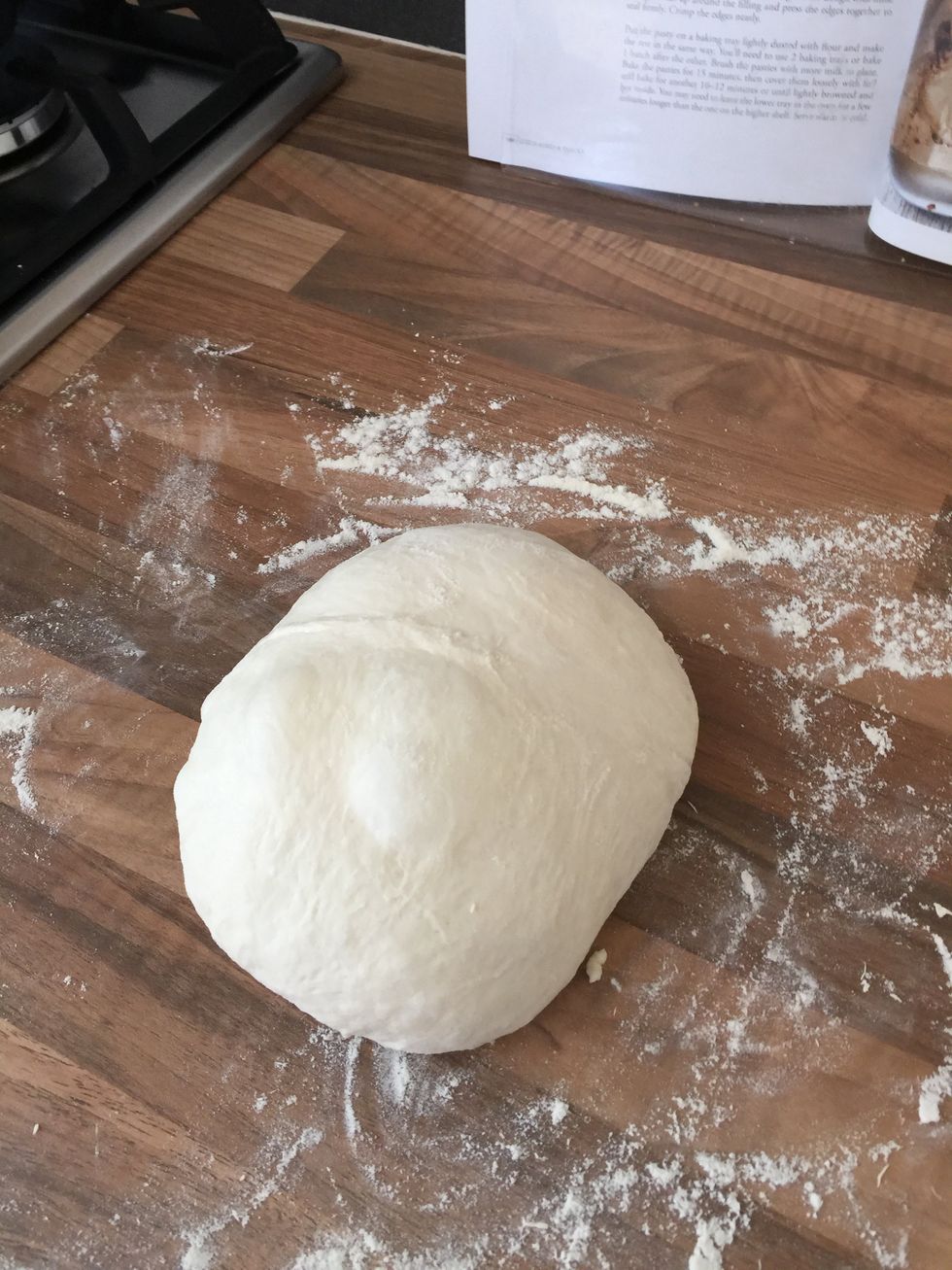 Use the flour on the surface and put some on your hands to gently cup and stretch the dough into a ball. Try not to over-work or stretch the dough as it can knock the air out of it.