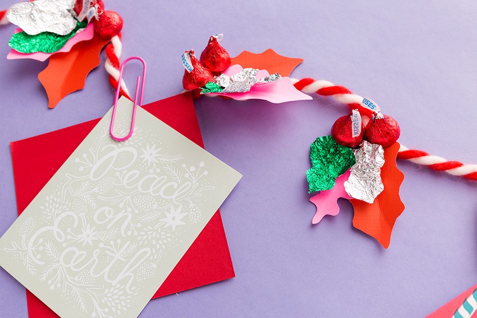 Use the HERSHEY\u2019S KISSES Holly Garland to hold your holiday cards and display them on a mantel or doorway!