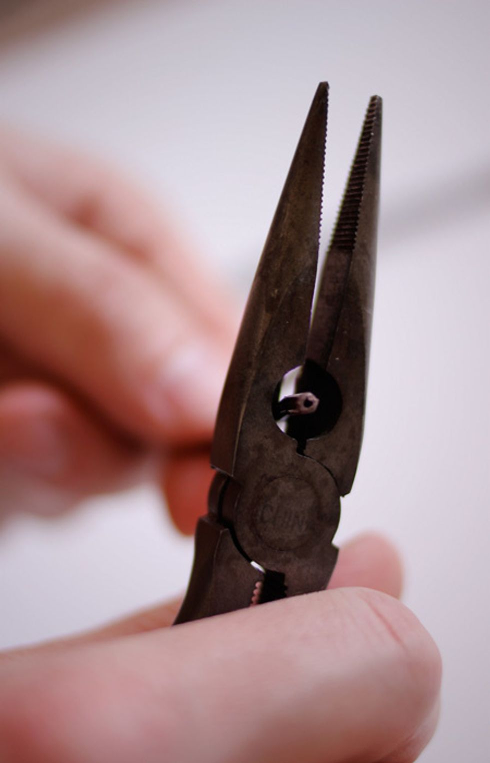 Use the hinged portion of the pliers to strip the plastic casing from the wires. Clamp with medium pressure to grip the plastic - then pull, being careful not to cut the wires in the process.