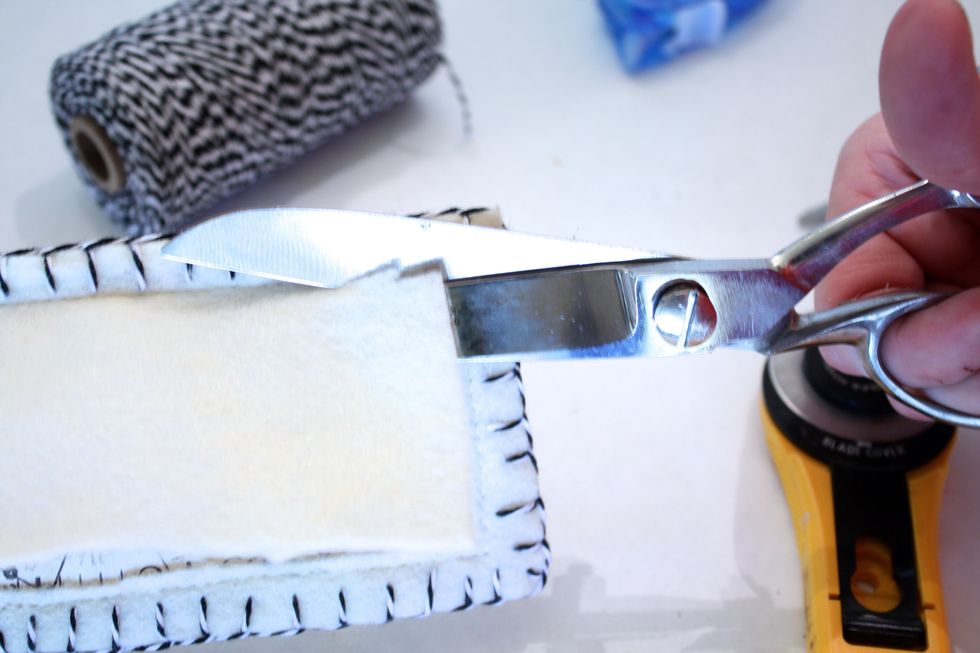 use the hole you cut to now trim close to the edge of your machine stitch, exposing your pretty paper underneath! (The paper also makes it easier to slip in your neeldes on the inside