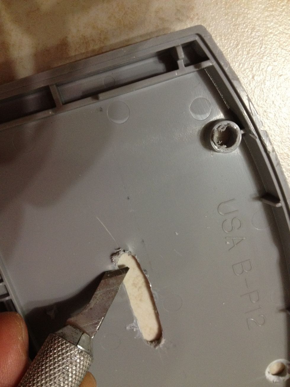 Use the knife to gently remove excess plastic made by the drill.
