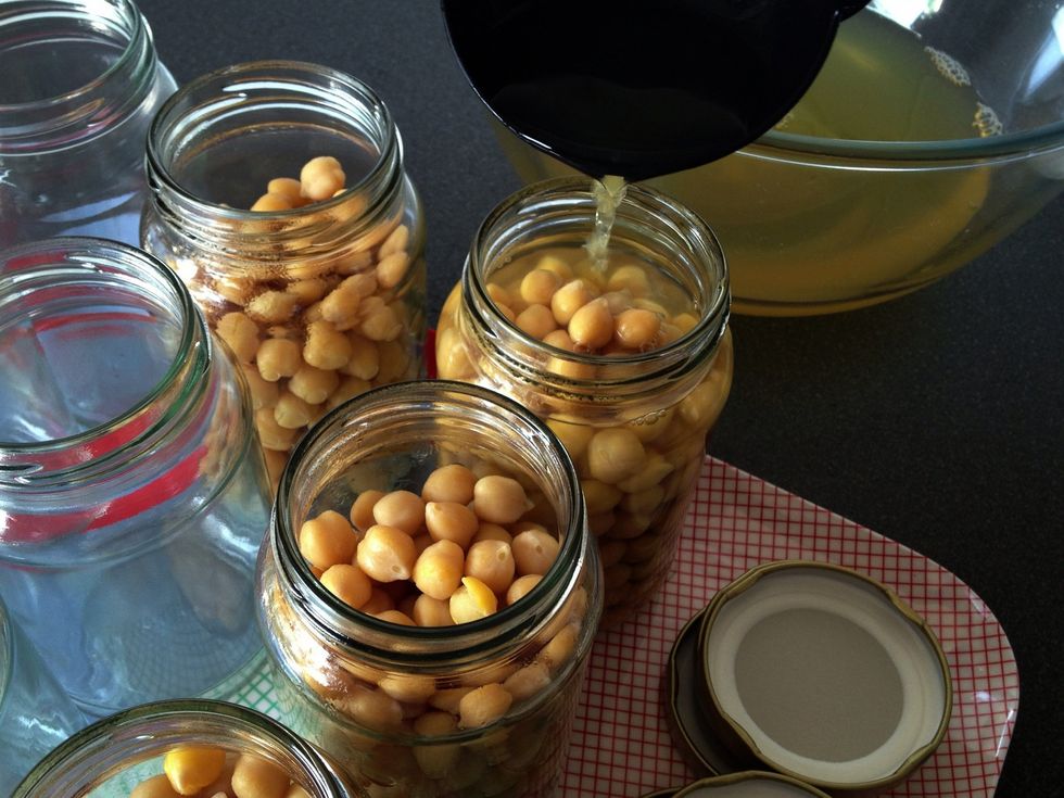 Use the ladle to pour the cooking liquid into each jar to just above the level of the beans.