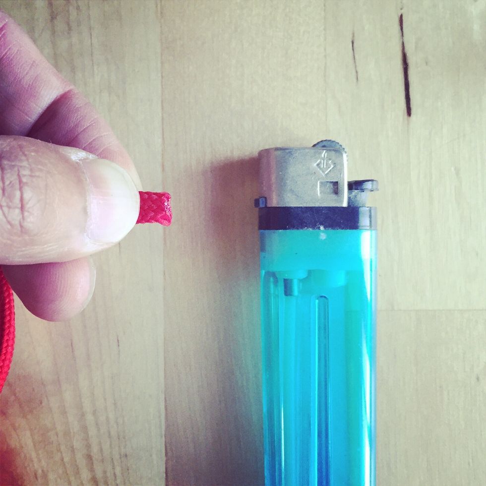 Use the lighter to burn off the frayed lanyard ends.