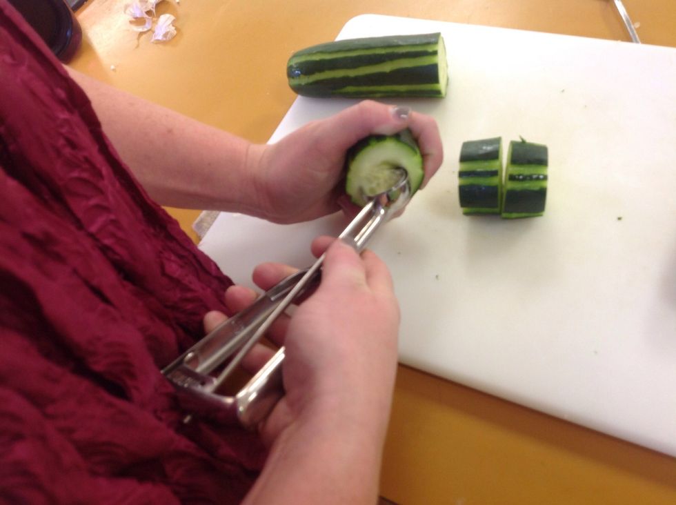Use the melon baller and scoop out the seeds making sure not to cut all the way through the cucumber. Leave a small bottom on the cucumber to keep the filling in.