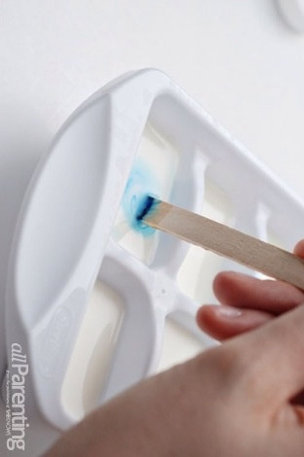Use the popsicle stick to mix a different color of food coloring into each tray. Don't forget you can combine colors: red and blue will make purple, yellow and blue will make green, and so on.