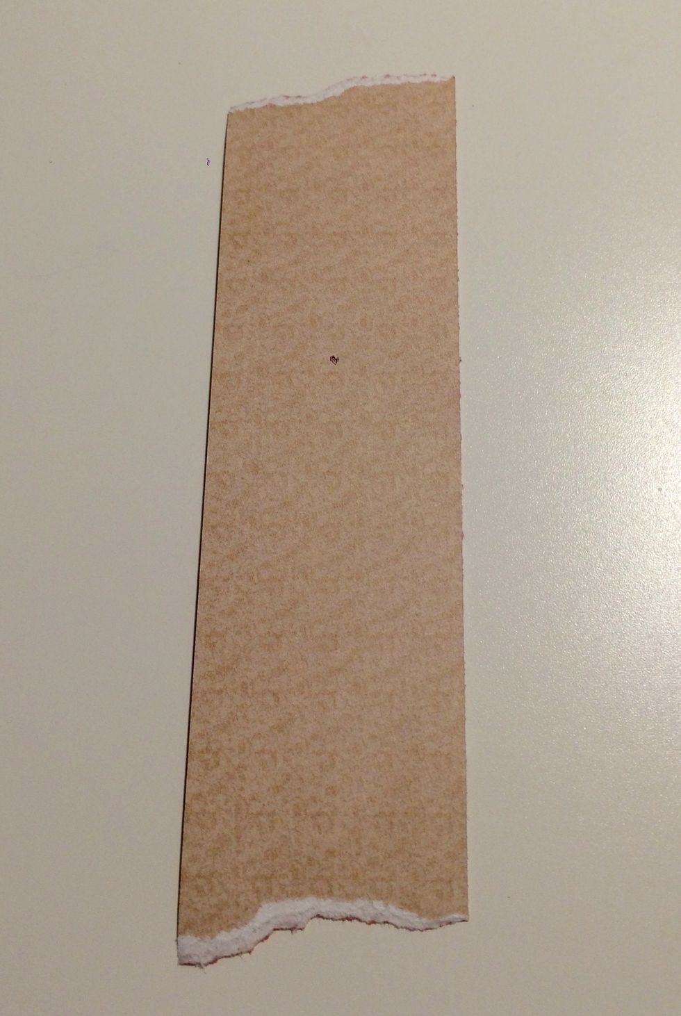 Use the rest of the cream paper from the solids pad. Cut a piece that measures 1 1/4" x 4 7/8". Tear a bit off the top and bottom of this paper.