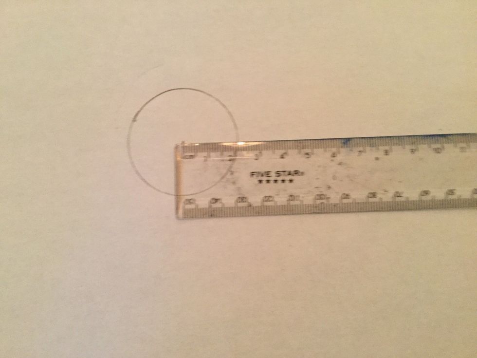 Use the small ruler and measure the distance from the center point of the circle to the outside of the circle, this is the radius.