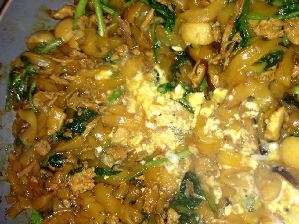Use the spatula to break the egg yolk and stir to blend with the egg white. Flip the noodles and cover the egg.