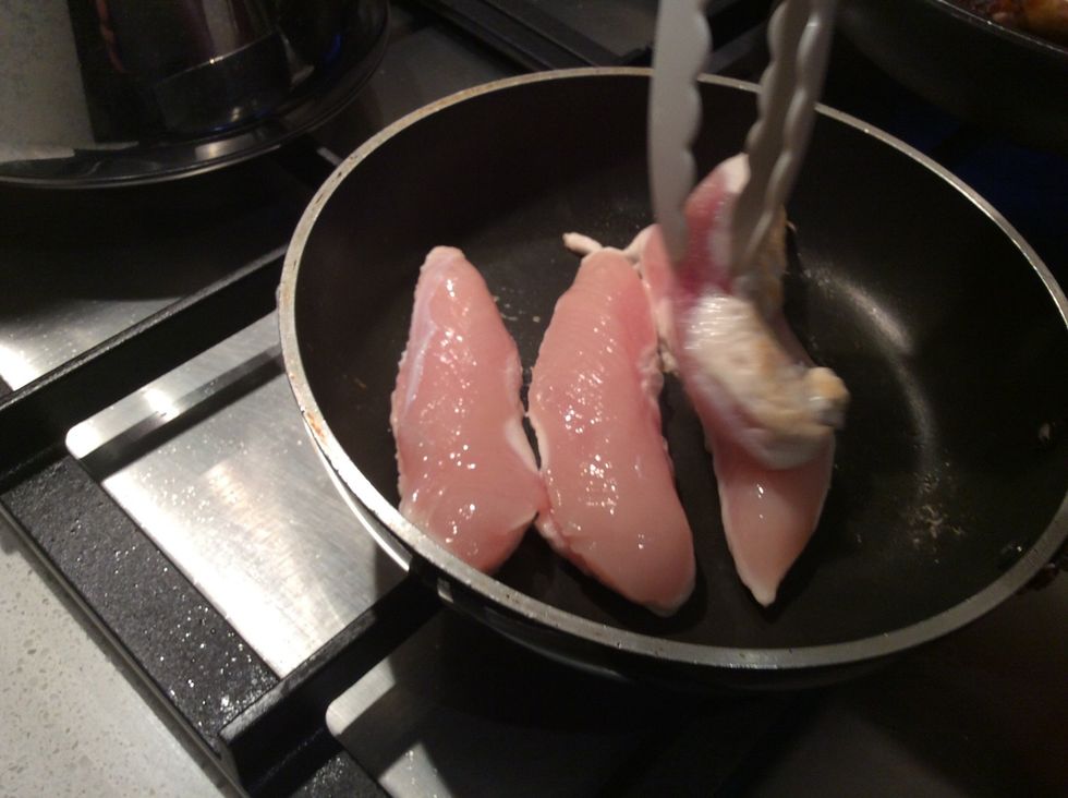 Use the tongs to turn the chicken over