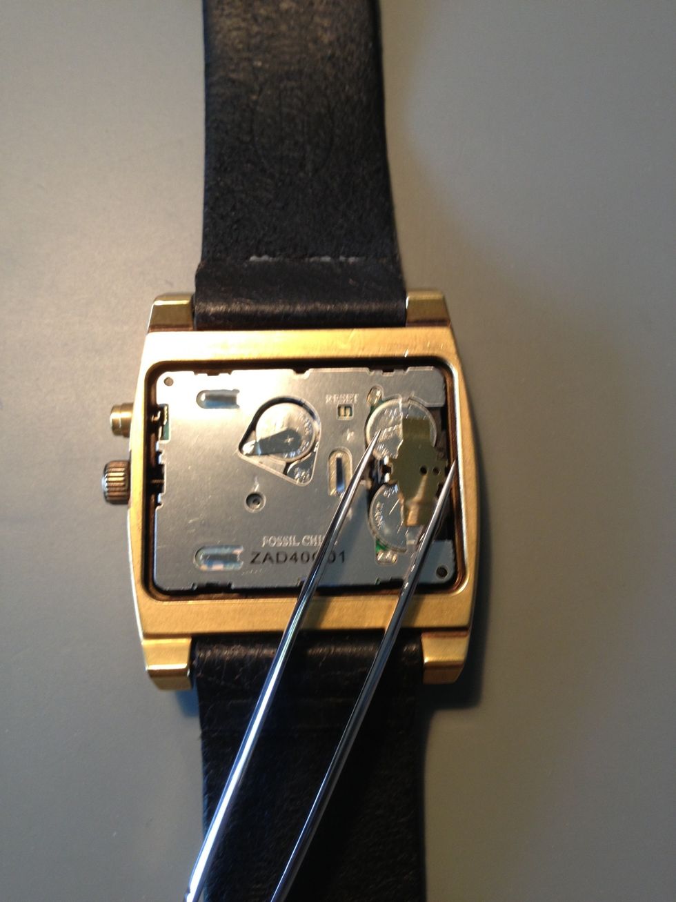 Use the tweezers to move the battery support and remove the battery. Make sure you replace the battery with another of the same type.