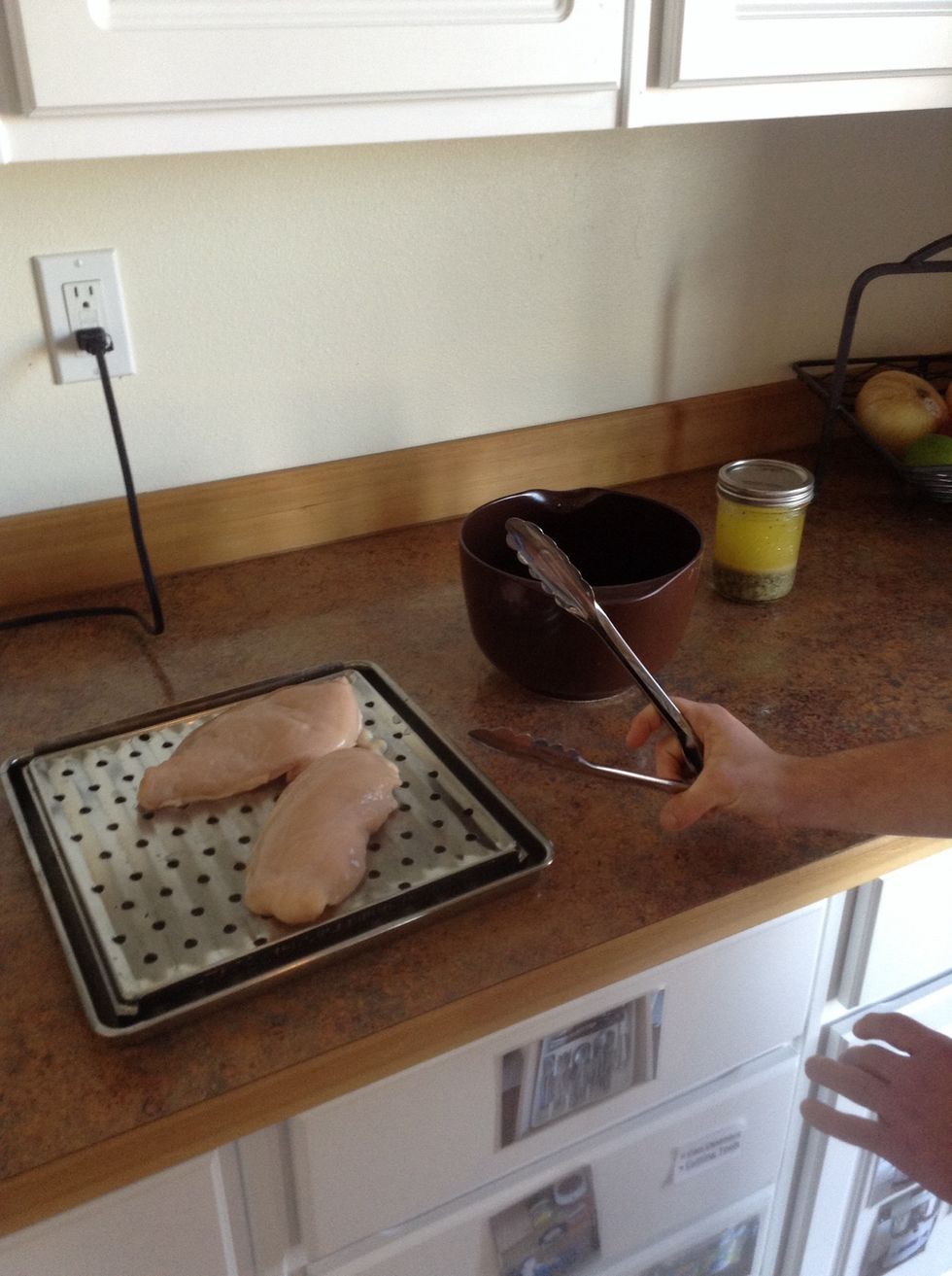 Use tongs to place chicken on baking sheet
