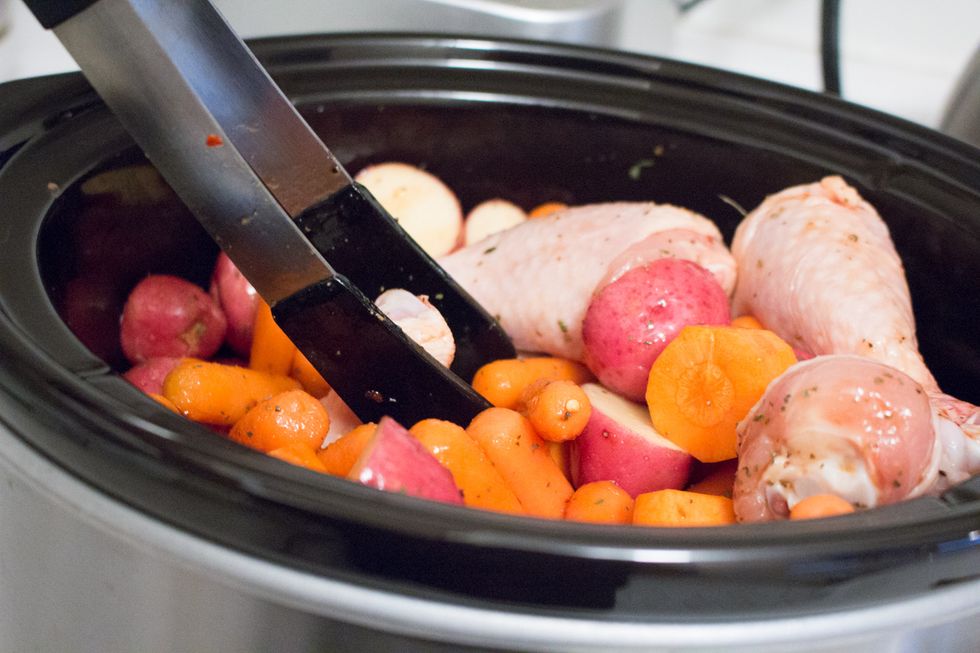 Use tongs to stir and spread the sauce to coat over all ingredients in the slow cooker.
