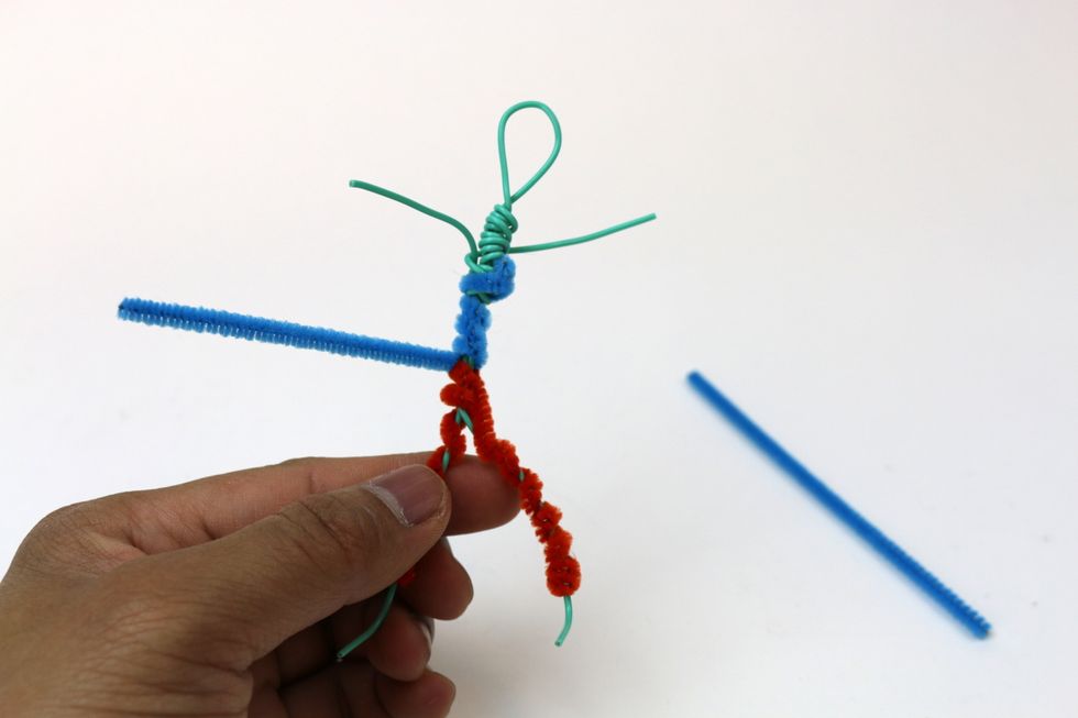 Use two pipe cleaners to cover the upper part of the figure. We might want to use a different color from the one we used to make pants for the figure.