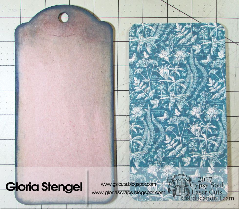 Use various pigment inks to ink the edges of a chipboard tag (8" x 4"). Allow the ink to dry. Cut decorative paper to 7 7/8" x 3 7/8" and round the four corners. (Graphic 45 Natures Sketchbook)