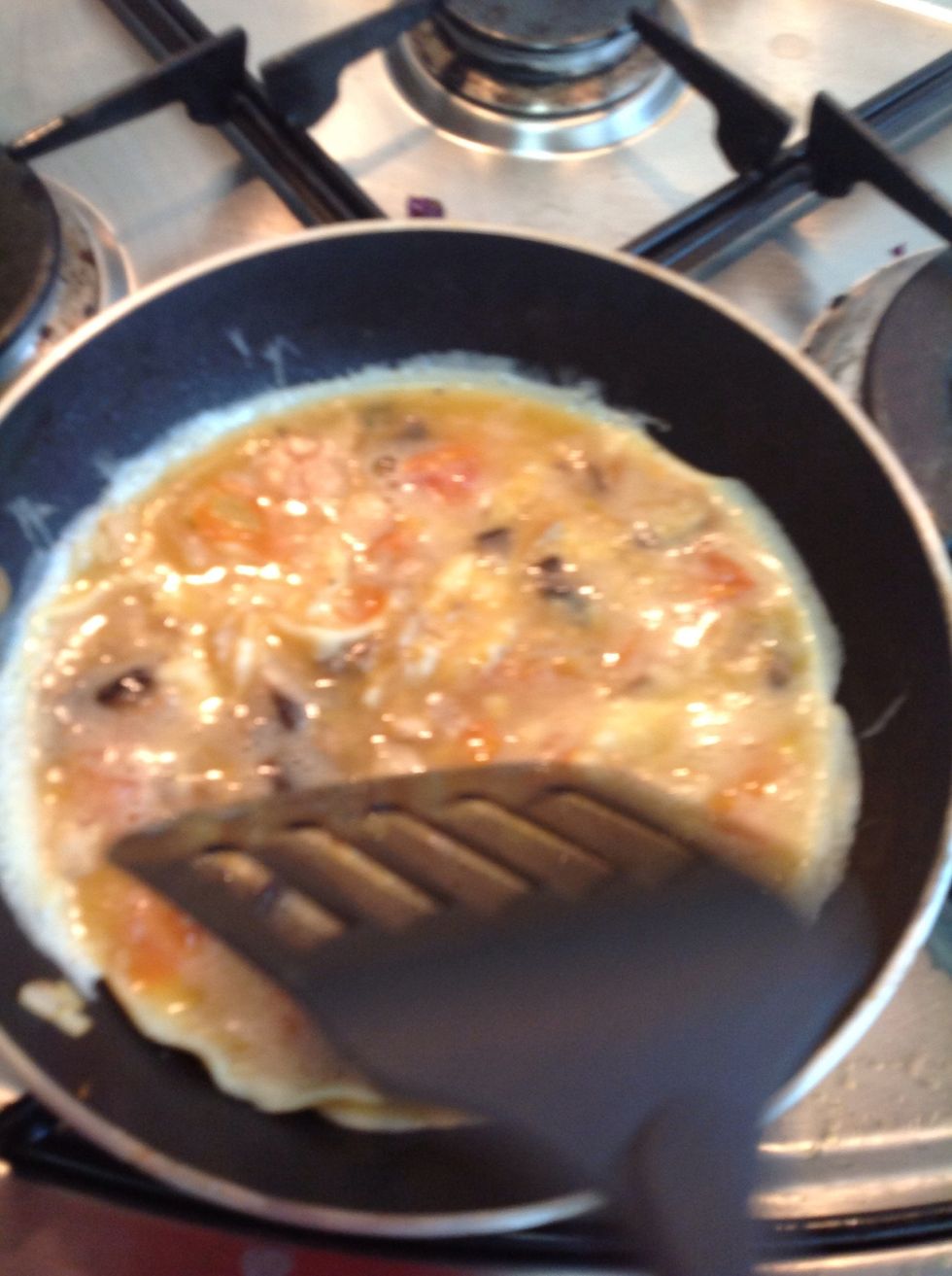 Use you spatula to break it up the cooking yoke a little to allow the liquid that hasn't touched the pan to cook as well.