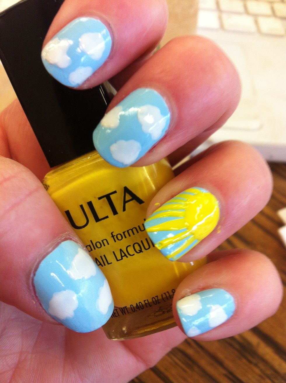 Use your dotting tool dipped in yellow polish  to cover the corner you left bare with a half circle. It's okay to cover the ends of your sun rays, this makes it look a little neater.