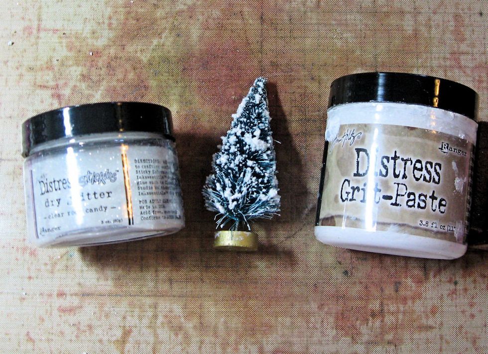 Use your finger to tap Distress Grit Paste onto the branches of a green bottle brush tree. Then dip the tree into Rock Candy Distress Glitter to add sparkle and shine.