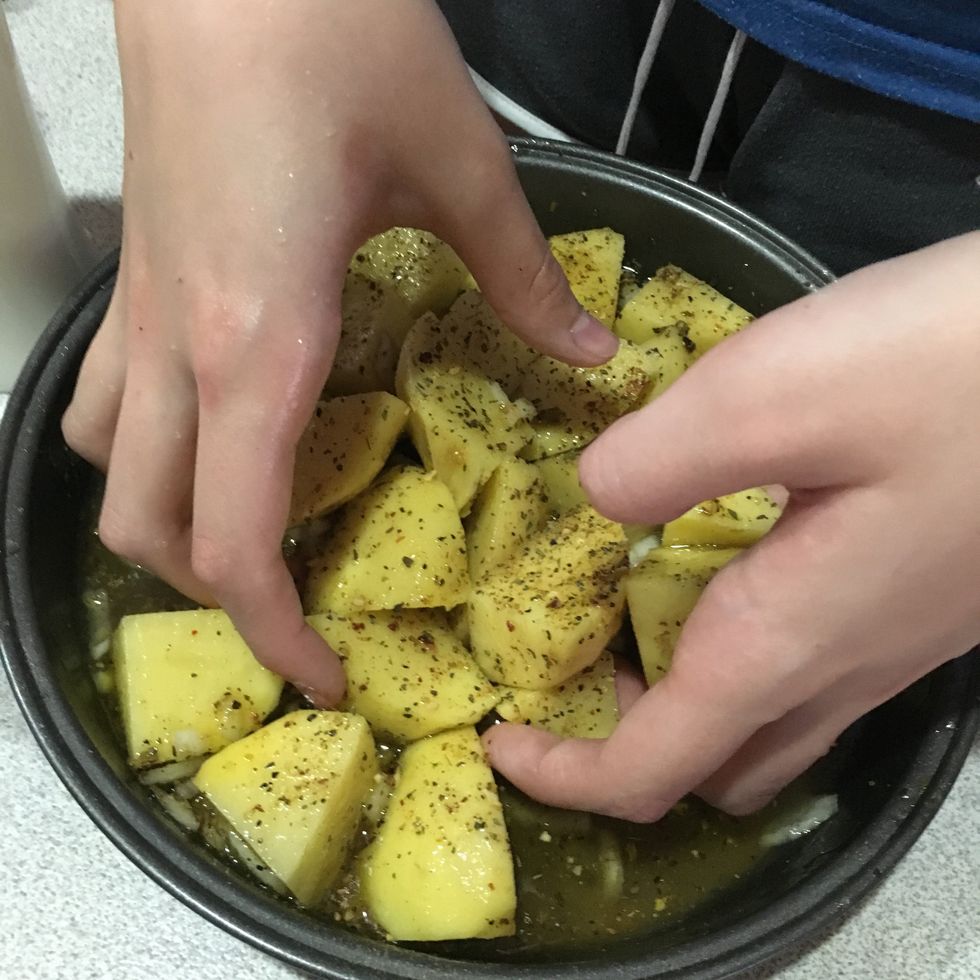 Use your hands to mix the potatoes together, ensuring every potato is covered.