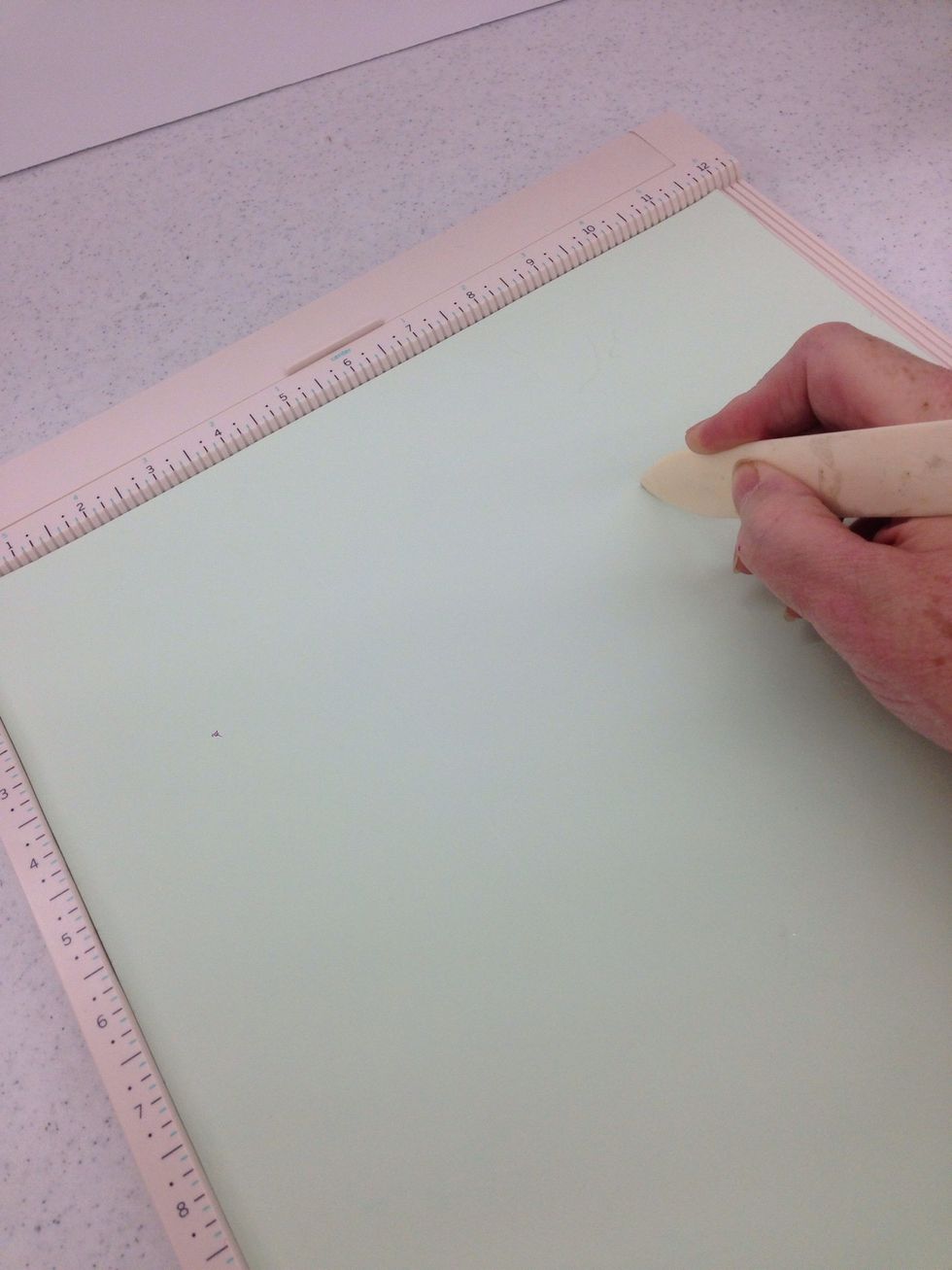 Use your scoring board and bone folder to score the paper at 4 inches and 8 inches. Turn the paper a quarter turn and repeat the scoring at 4 and 8 inches.