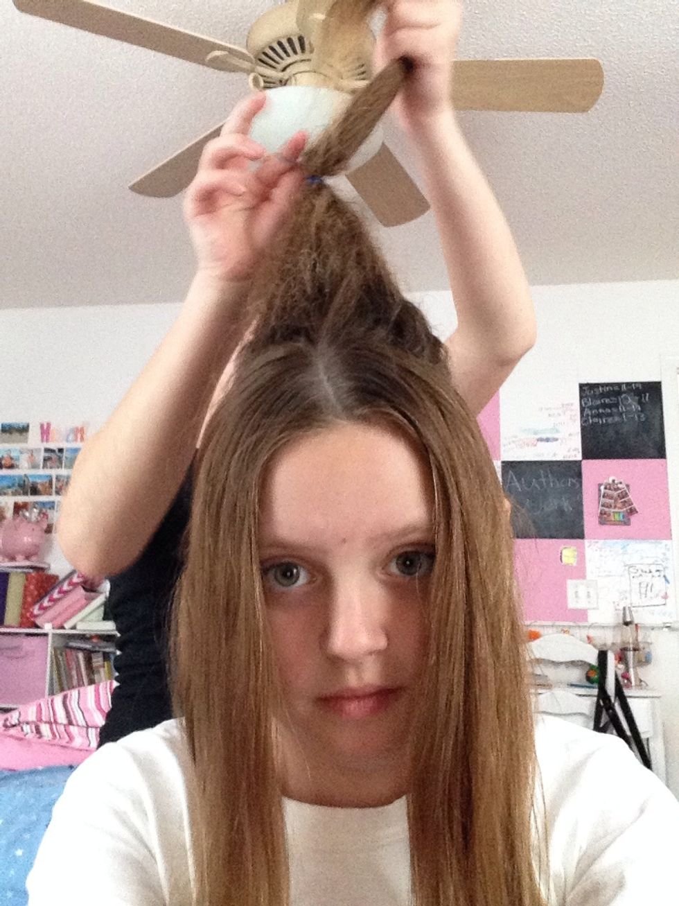 Use your small elastic band to tie hair about half way up the beehive. WARNING! If your beehive is messy brush it out before putting in the elastic band. We had to do that.