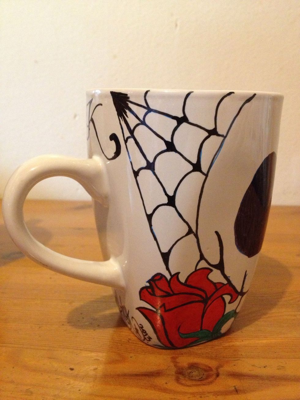 Used red, green and black markers to color in and outline. The spiderwebs were my idea \ud83d\udc4d and her initial "K"