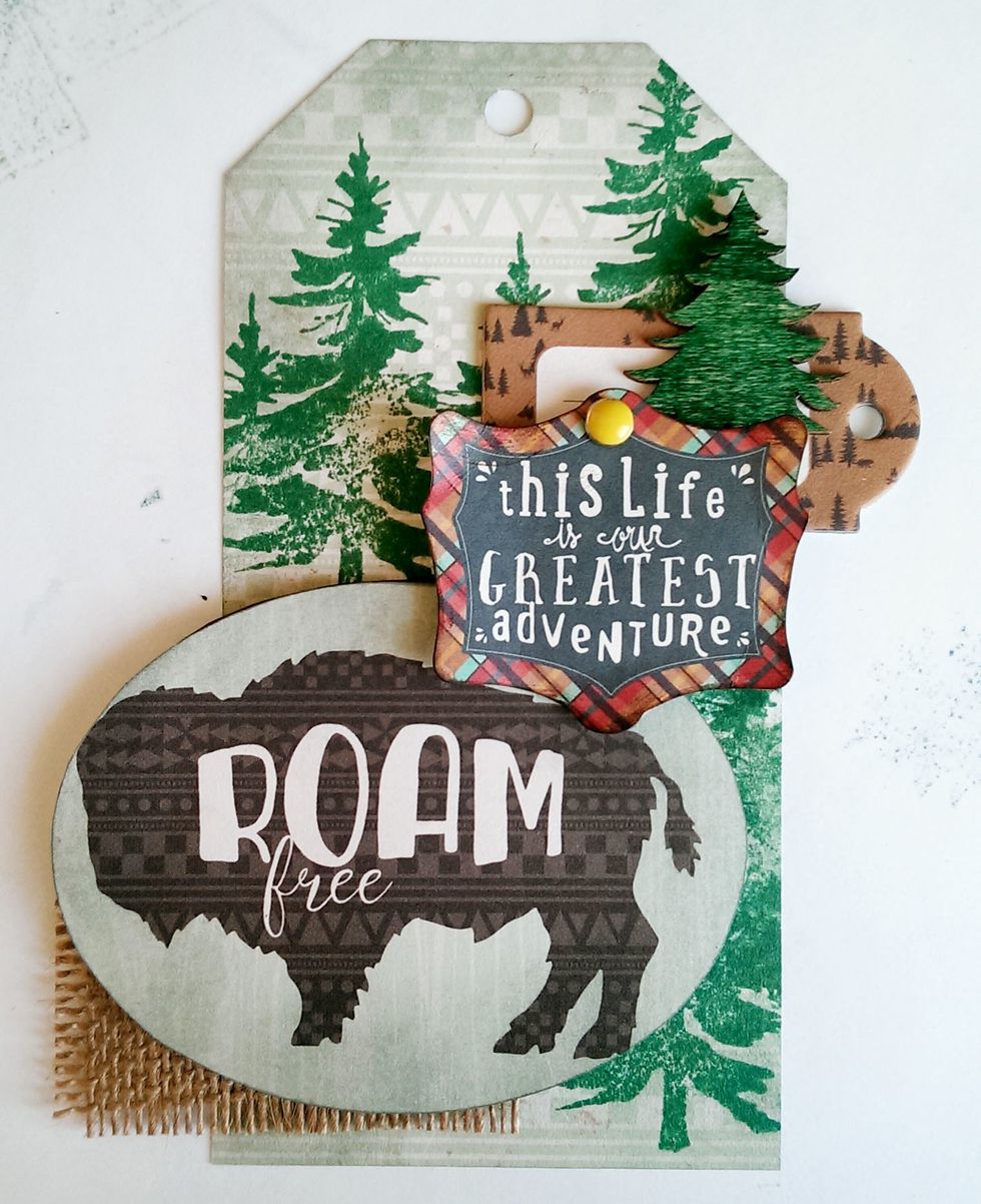 Using 3D Foam Dots, secure the Brad saying on top of the brown chipboard and Buffalo oval.