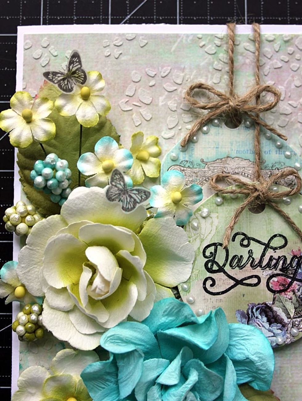 Using 582340 - Royal Menagerie \u2013 Cling Stamps set, stamp two butterflies onto vellum. Trim. Adhere to the flowers as shown.