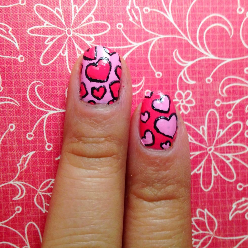Using a black polish, outline the hearts.