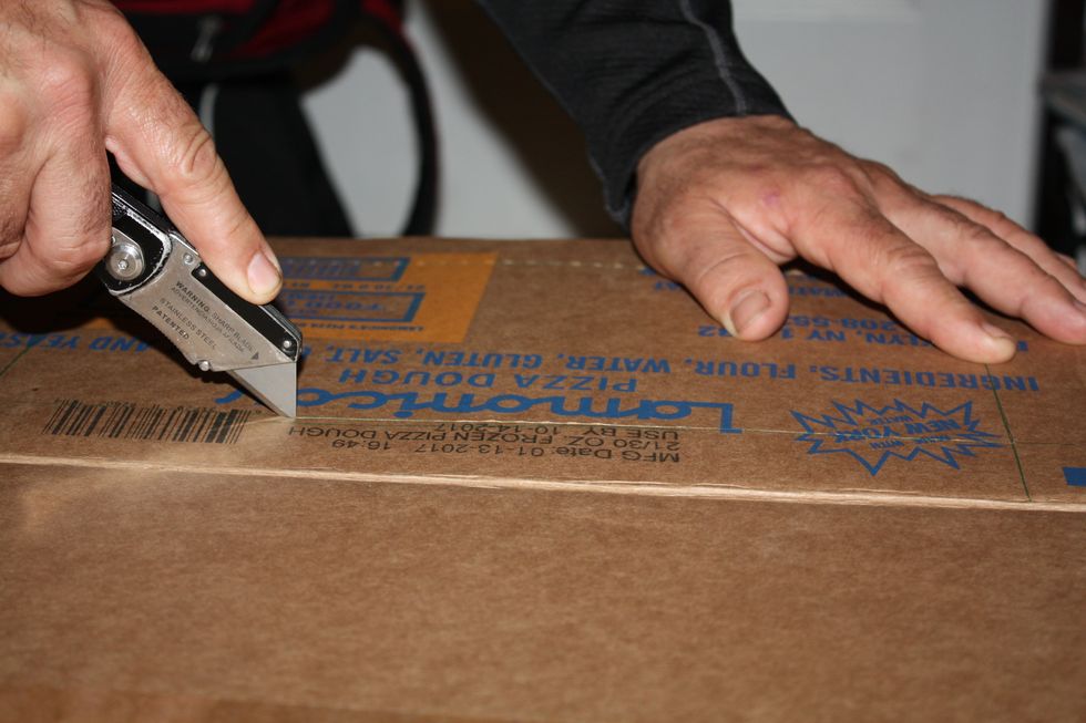 Using a box cutter, cut along the lines that you drew