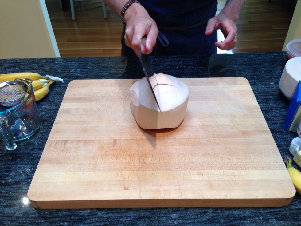 Using a butcher knife carefully cut a opening in the top of the young coconut. I usually make 4 cuts in the top essentially cutting a square.