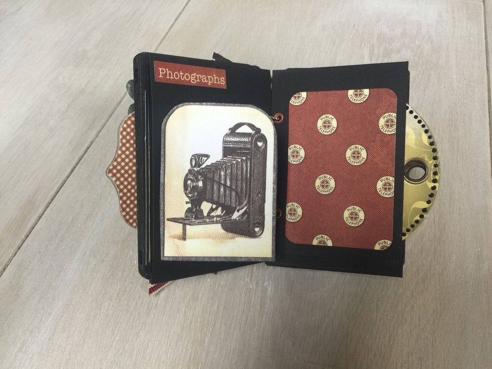Using a cardstock about 1x2", scored at 1/2" length wise to make a flap from the vintage camera cutout.