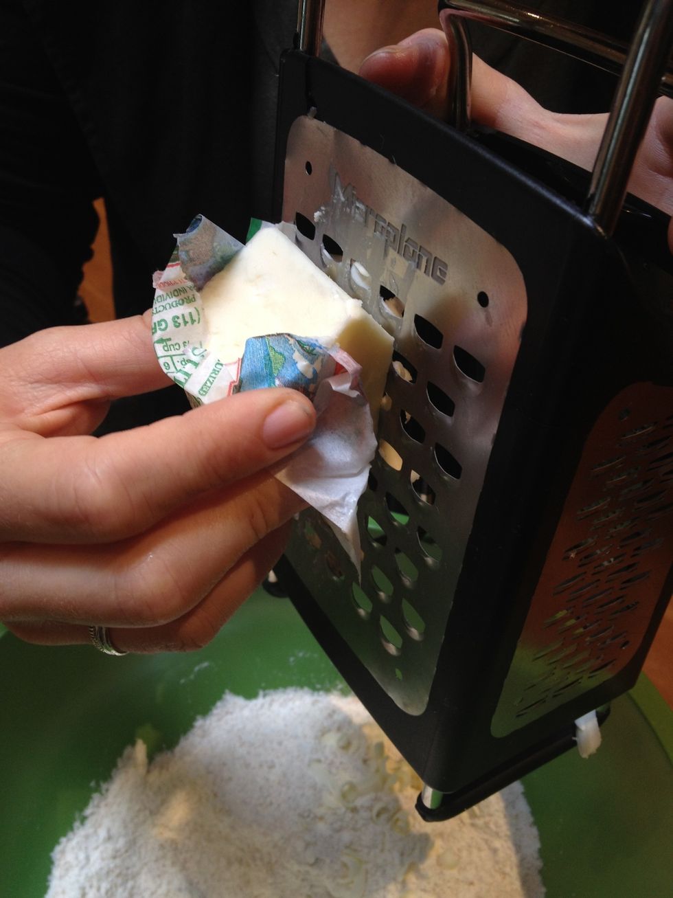 Using a cheese grater, grate the frozen butter directly into the dry mixture.