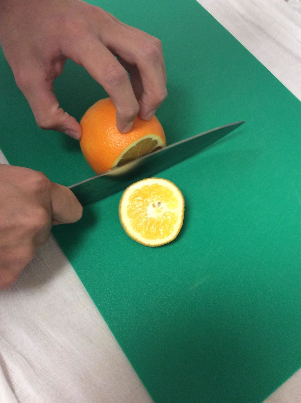 Using a chef's knife cut off one end of the orange crosswise.