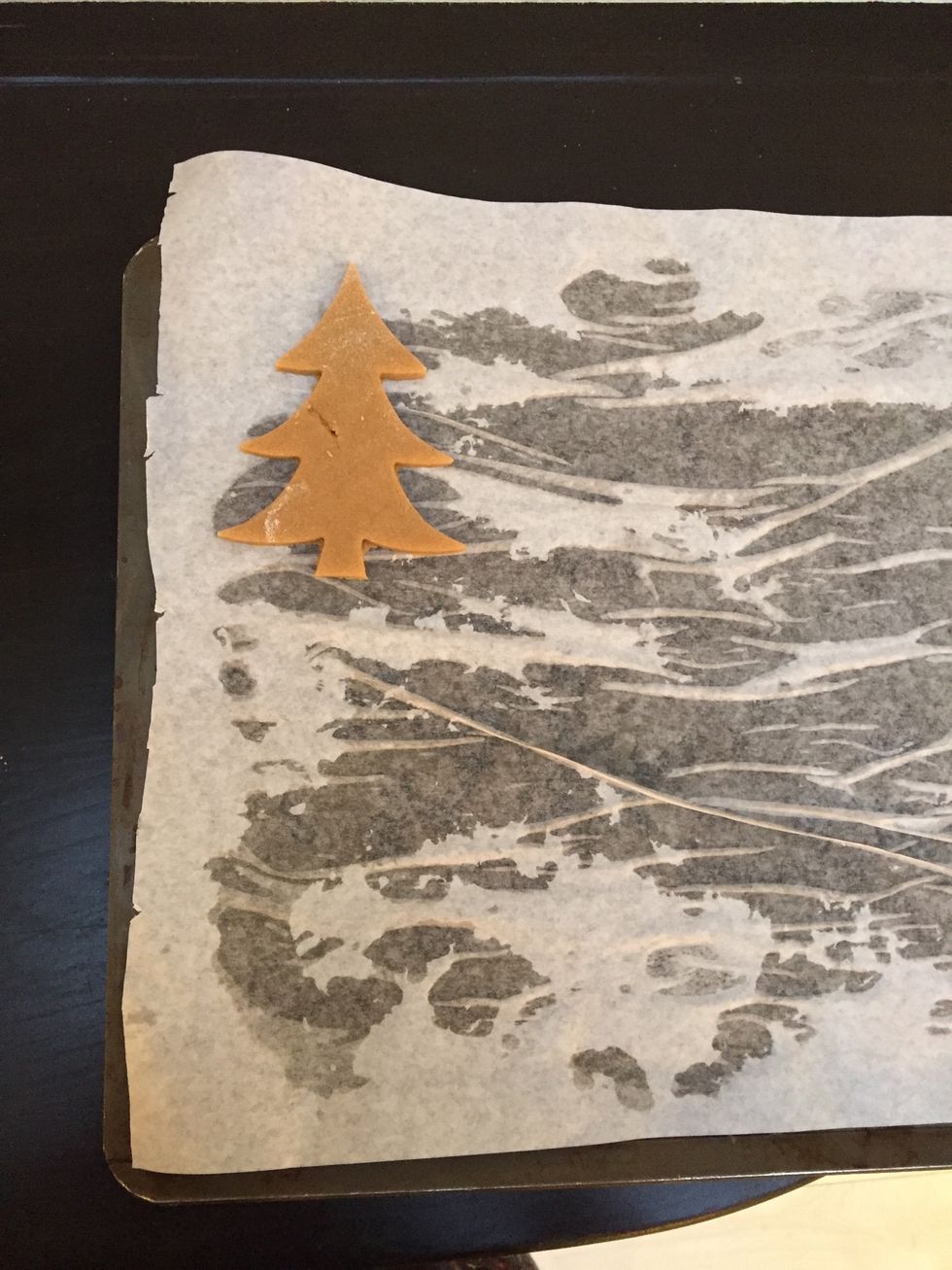 Using a Christmas Tree cookie cutter, cut out the shapes and place them on a lined baking tray.