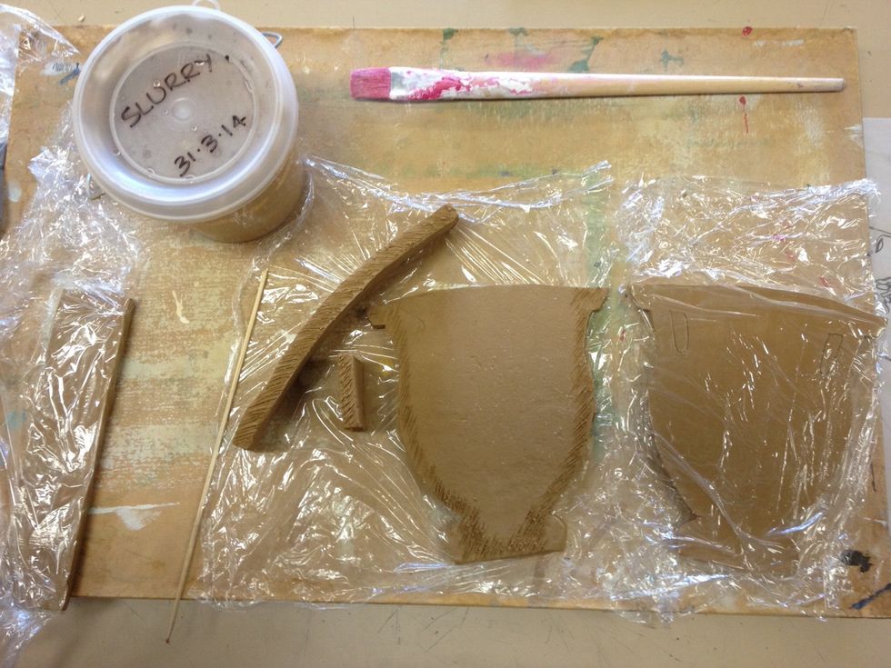 Using a clay tool or skewer, score each contact surface to be joined- around one face of each template shape, and all edges of the sides and base.