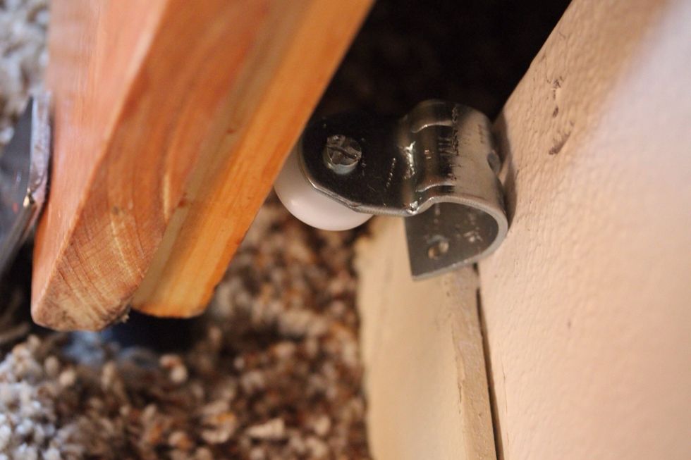 Using a closet door wheel I fashioned a track to keep the door straight when opening and closing.