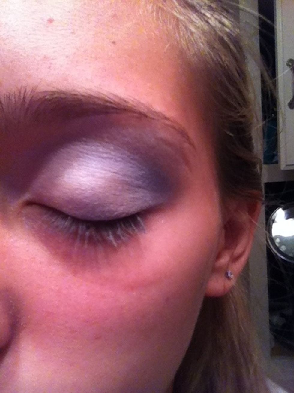 Using a contour or regular eyeshadow brush apply the medium shade blue (or) green to the crease and create a v shape between the crease and the lid.