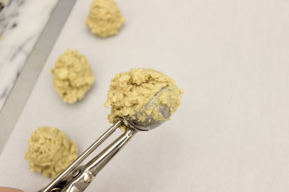 Using a cookie scooper, scoop out heaping balls of the white chocolate chip macadamia nut dough onto parchment paper lined cookie sheets.