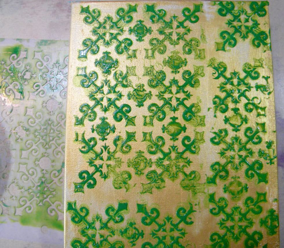 Using a credit card or palette knife, scrape the green mixture through the Gothic Stencil.