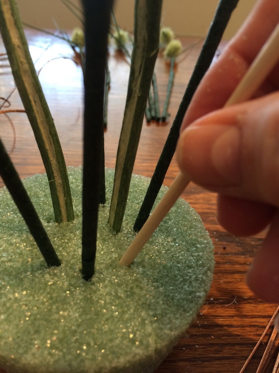 Using a dowel, pre-poke holes where you want to place the leaves. Then push in the stems.