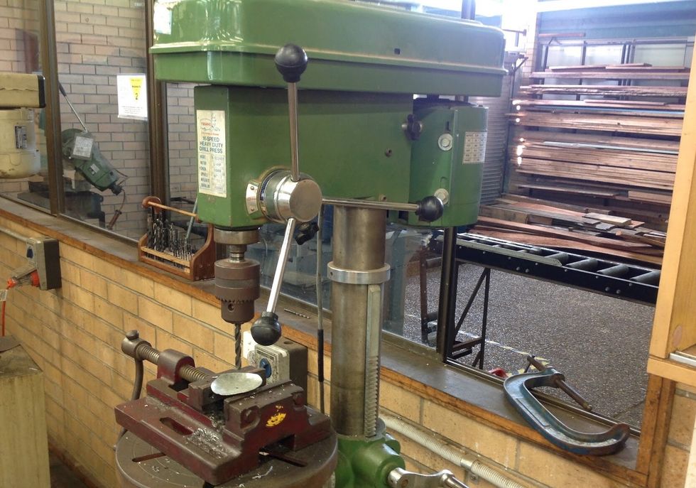 Using a drill press and a clamp, place you circle under the drill press and line your drill piece up so it lines up with your indent. Clamp your circle and drill through it.