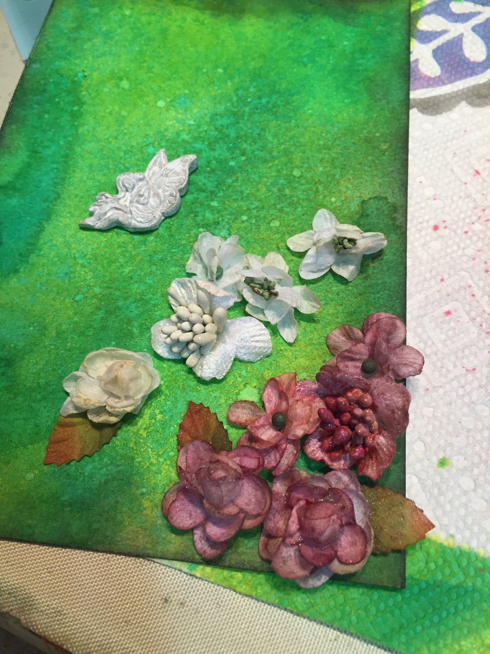 Using a dyeable flowers, spray with Wild Orchid, Heart, and Juicy Colorations.  When dry, mist with Stirling Fairy Dust. Glue in lower right hand corner.