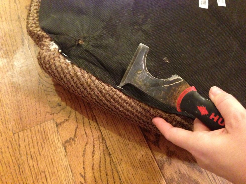 Using a five in one and needle nose pliers, carefully remove the staples from the fabric cover.