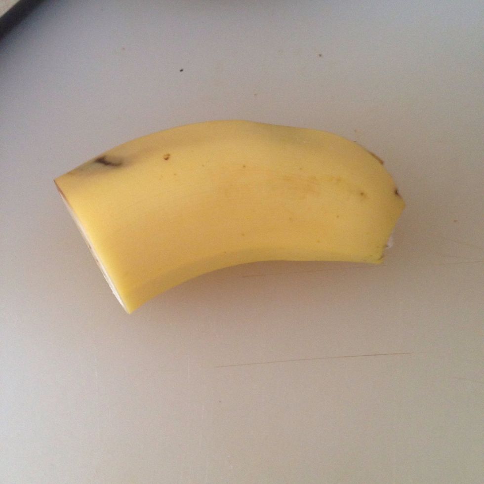 Using a fork mashup half a banana in a cup